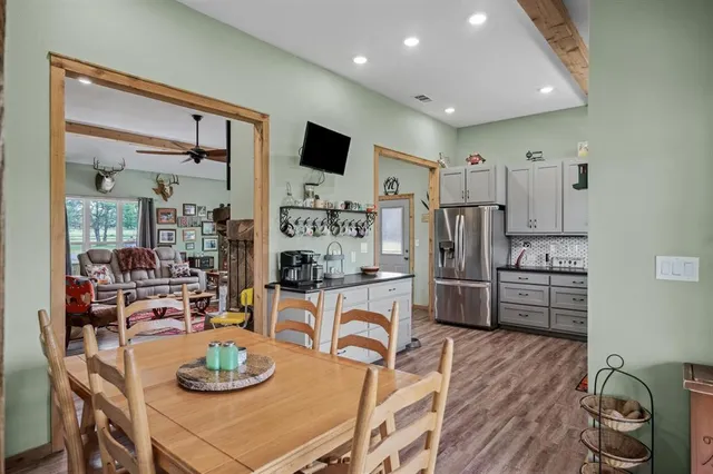 a kitchen with stainless steel appliances kitchen island granite countertop a table and chairs in it