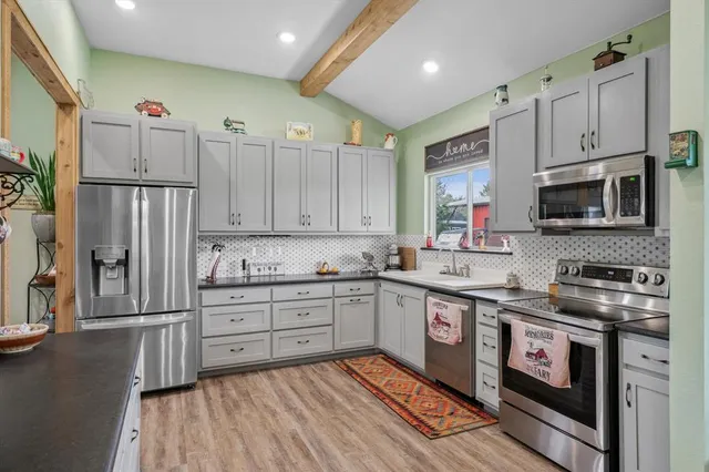 a kitchen with stainless steel appliances granite countertop a stove a sink and a refrigerator