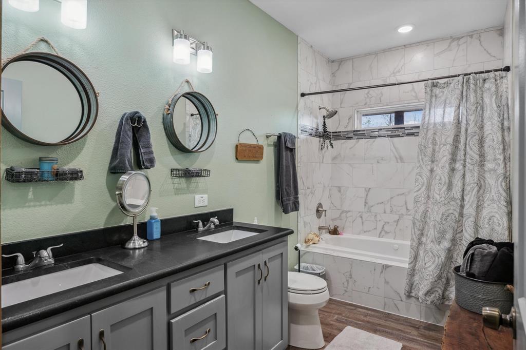 9292 County Road 346 Terrell, TX 75161 - Photo 24 of 40 a bathroom with a granite countertop toilet a sink and a mirror