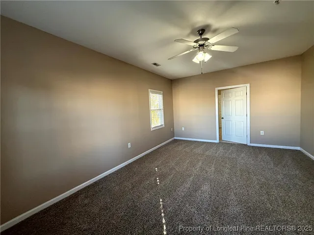 a view of a livingroom with a ceiling fan and window