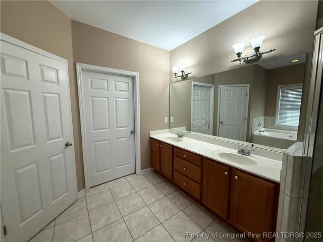 a spacious bathroom with a double vanity sink a large mirror and a shower