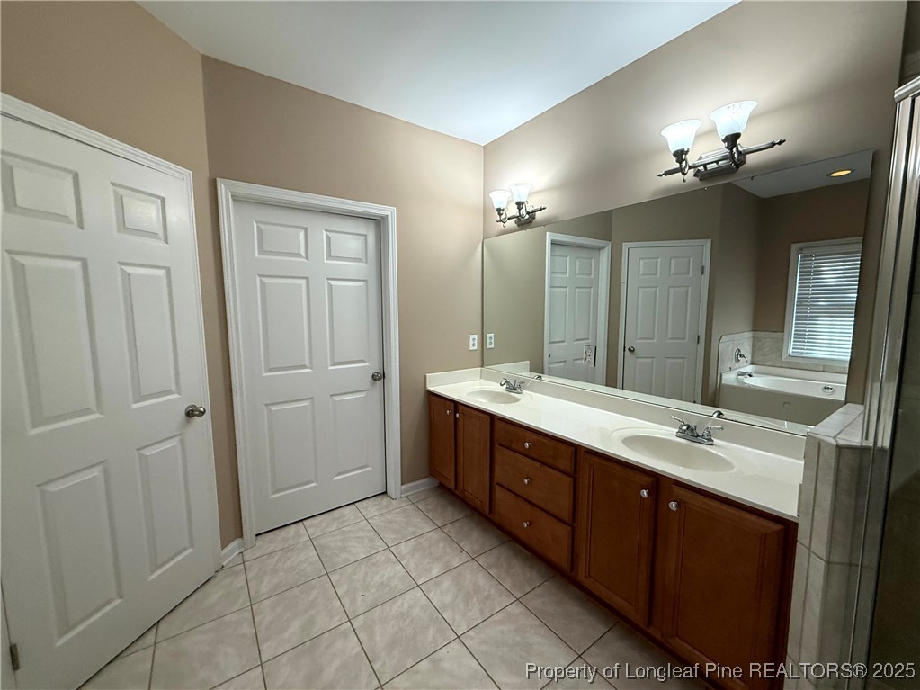 635 Marsh Tree Street, Unit 208 Fayetteville, NC 28314 - Photo 16 of 20 a spacious bathroom with a double vanity sink a large mirror and a shower