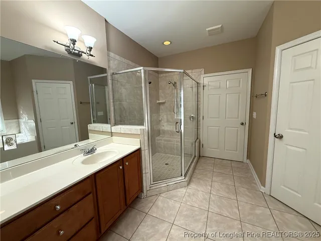 a bathroom with a shower sink and mirror