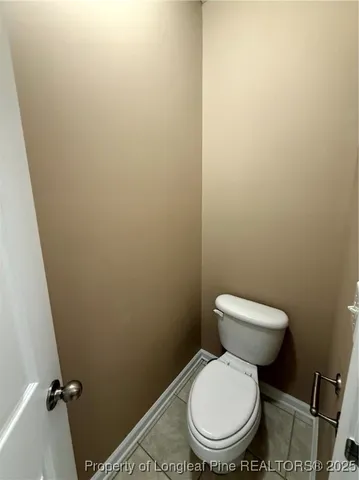 a white toilet sitting in a bathroom next to a wooden wall