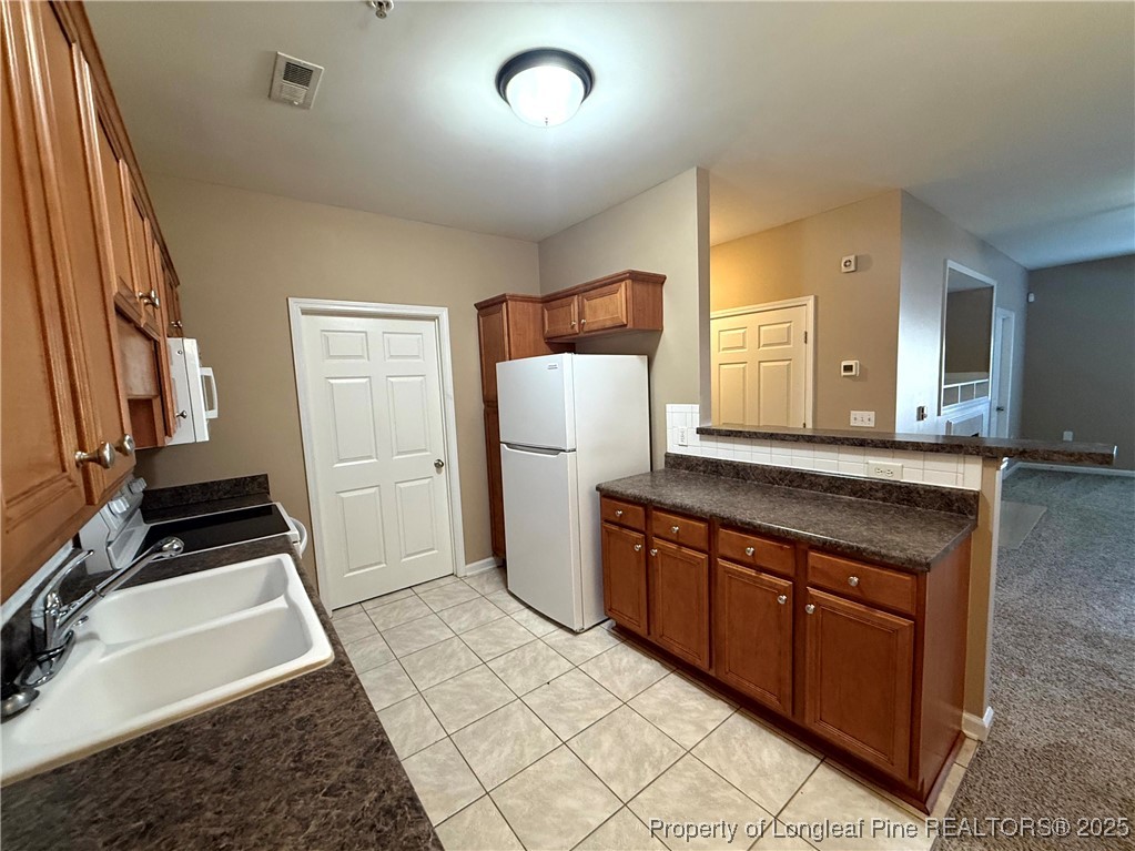 635 Marsh Tree Street, Unit 208 Fayetteville, NC 28314 - Photo 4 of 20 a kitchen with granite countertop a refrigerator and a sink
