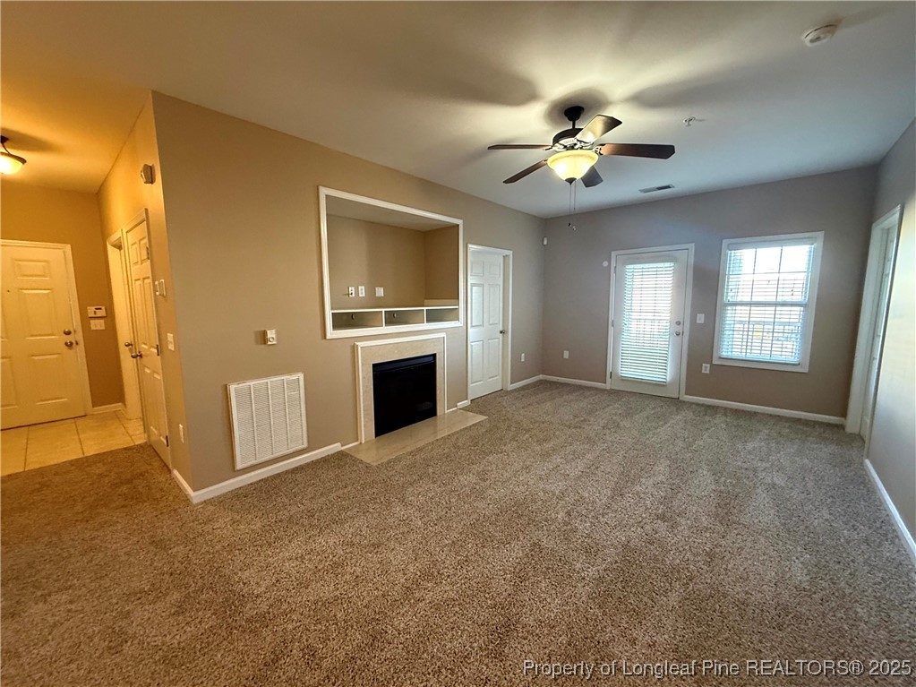 635 Marsh Tree Street, Unit 208 Fayetteville, NC 28314 - Photo 8 of 20 a view of a livingroom with a ceiling fan a flat screen tv and a fireplace