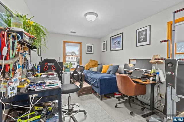 a bedroom with a bed dresser and a flat tv screen