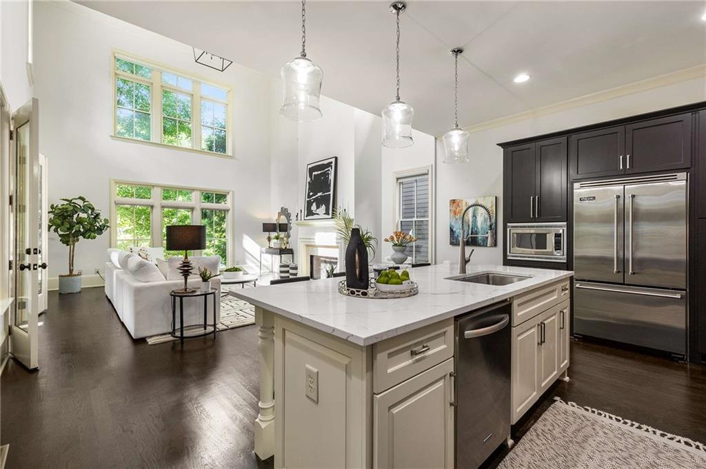 147 Hubbard Road Woodstock, GA 30188 - Photo 14 of 56 a open kitchen with stainless steel appliances granite countertop a stove a sink dishwasher a refrigerator and a dining table with wooden floor