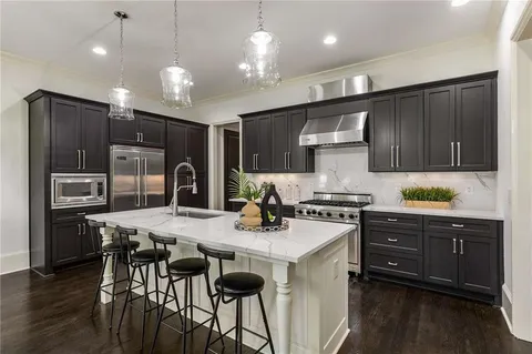 a kitchen with a stove a refrigerator and a microwave