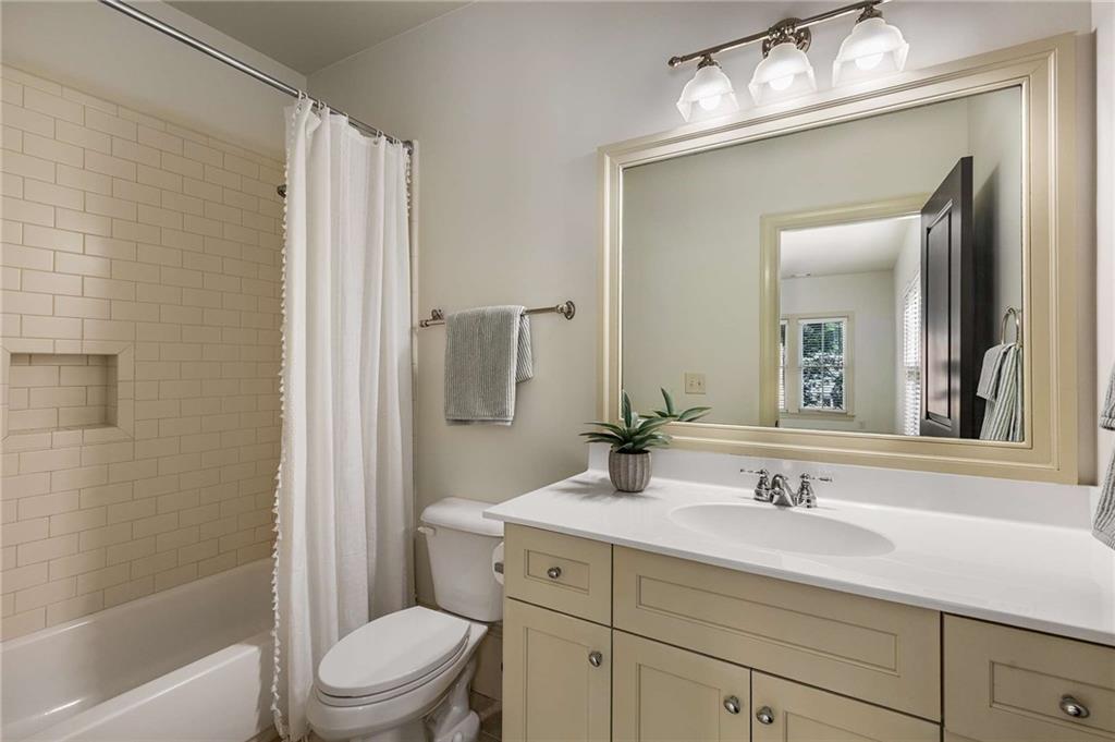 147 Hubbard Road Woodstock, GA 30188 - Photo 44 of 56 a bathroom with a sink a toilet a mirror a vanity and shower