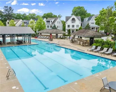 a view of a house with a big yard and large trees