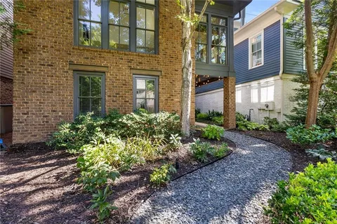 a view of a swimming pool with a yard and large trees