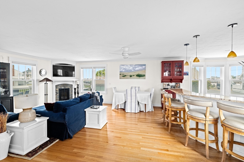 89 Lighthouse Road Scituate, MA 02066 - Photo 8 of 42 a living room with furniture a fireplace a flat screen tv and kitchen view