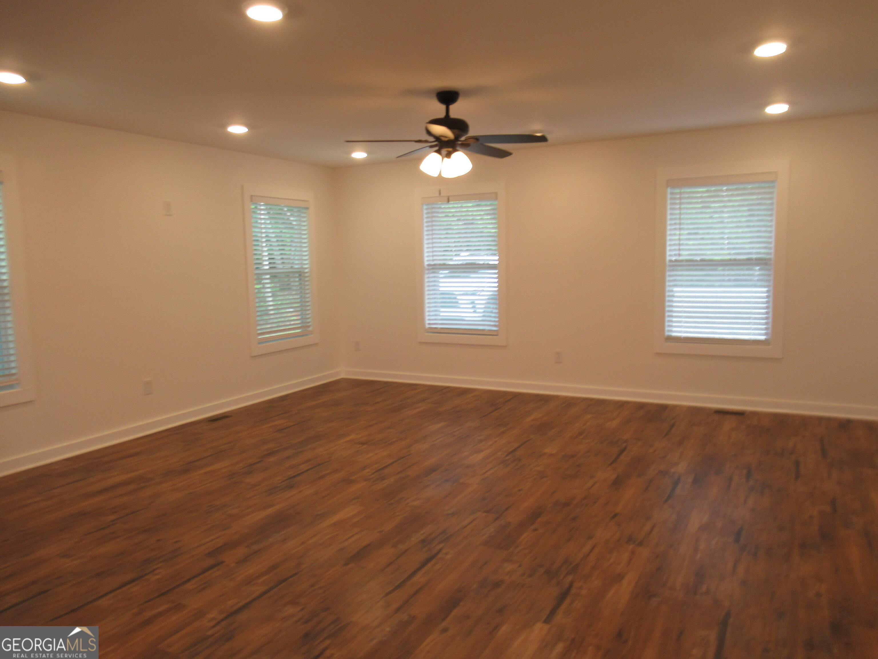 765 Old Kerns Road Dawsonville, GA 30534 - Photo 12 of 36 a view of an empty room with wooden floor and a window