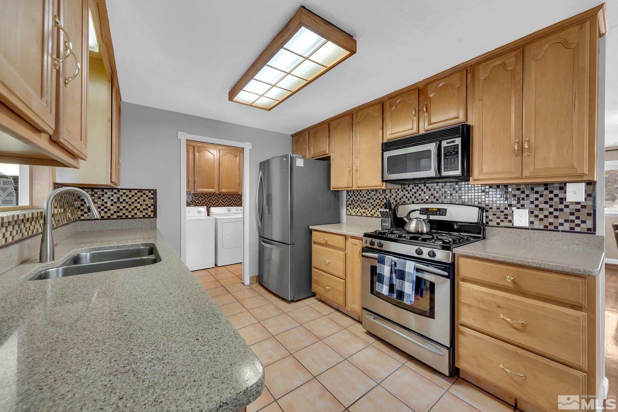 1830 West 7th Street Reno, NV 89503 - Photo 13 of 36 a kitchen with stainless steel appliances granite countertop a stove a sink and a microwave