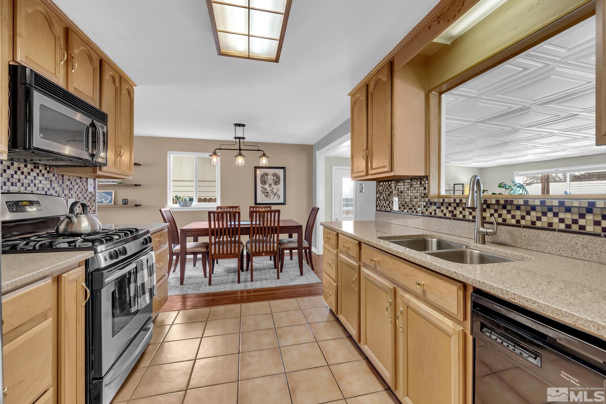 1830 West 7th Street Reno, NV 89503 - Photo 14 of 36 a kitchen with stainless steel appliances granite countertop a stove a sink and a microwave
