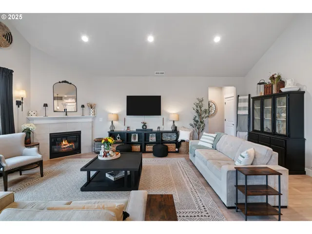 a living room with furniture a fireplace and a flat screen tv