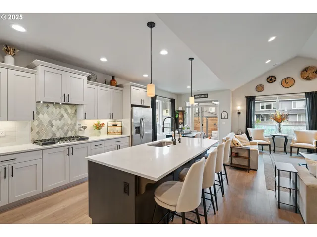 a kitchen with stainless steel appliances granite countertop a stove refrigerator and cabinets