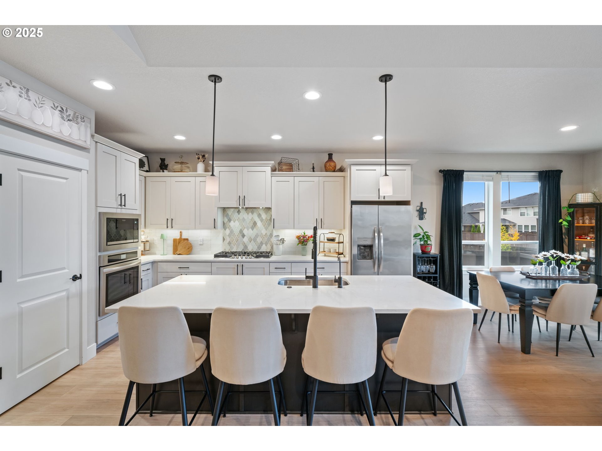 8842 North 3rd Circle Ridgefield, WA 98642 - Photo 22 of 46 a kitchen with stainless steel appliances kitchen island granite countertop a dining table chairs and white cabinets