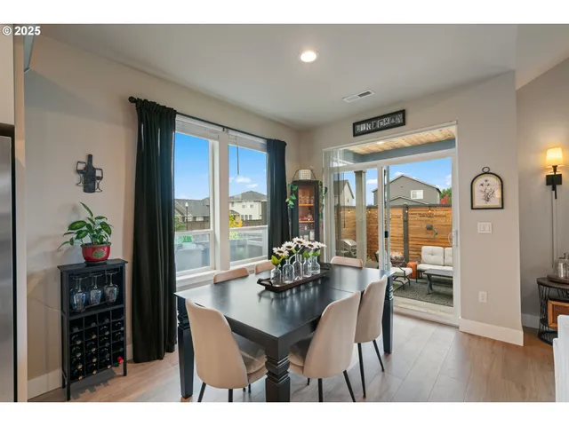 a dining room with furniture potted plants and wooden floor