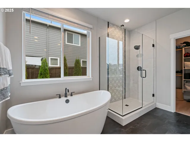 a bathroom with a white bath tub sitting next to a window