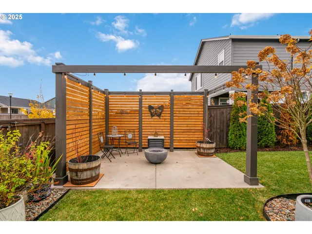 a view of a patio with table and chairs potted plants with wooden fence