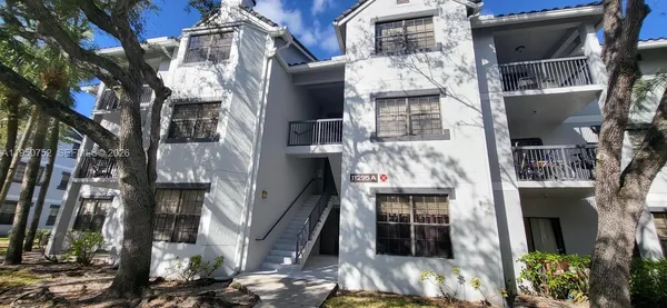 a front view of a multi story building with yard