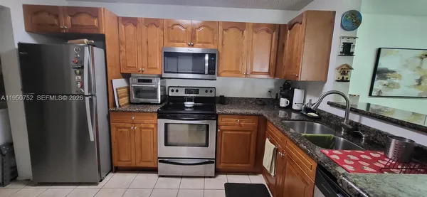 a kitchen with stainless steel appliances granite countertop a refrigerator stove and sink