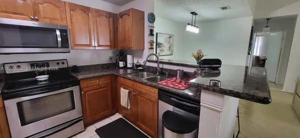a kitchen with stainless steel appliances granite countertop a stove microwave and refrigerator