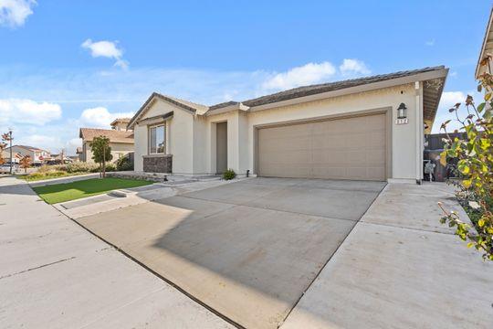 912 Loon Street Lathrop, CA 95330 - Photo 14 of 27 a front view of a house with a yard and garage