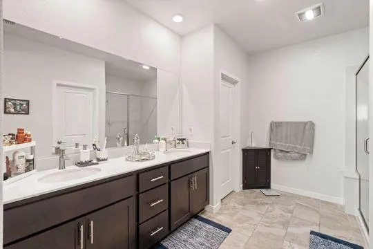 a en suite bathroom with double vanity and a mirror