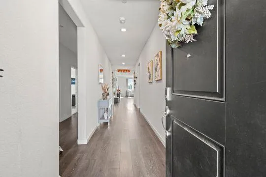 a view of a hallway with wooden floor and staircase
