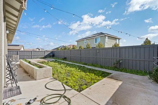 a view of a backyard with furniture and wooden fence