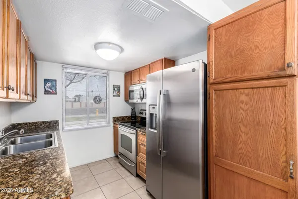 a kitchen with stainless steel appliances granite countertop a refrigerator and a sink