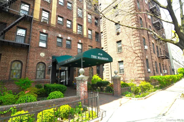 a front view of a building with a garden and plants