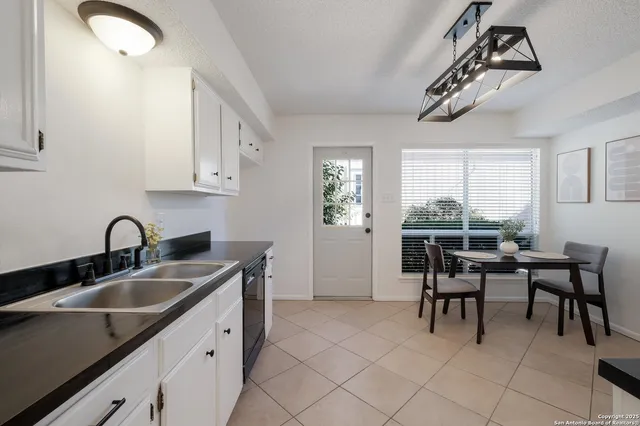 a kitchen with a sink cabinets and dining table chair