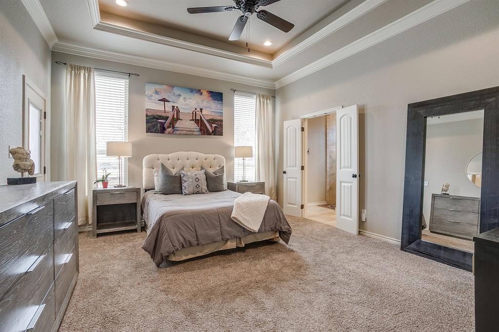 1615 Sanger Drive Springtown, TX 76082 - Photo 16 of 40 a spacious bedroom with a bed a couch and a chandelier