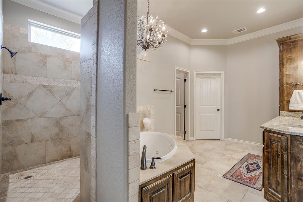 1615 Sanger Drive Springtown, TX 76082 - Photo 17 of 40 a spacious bathroom with a granite countertop sink a mirror and a shower