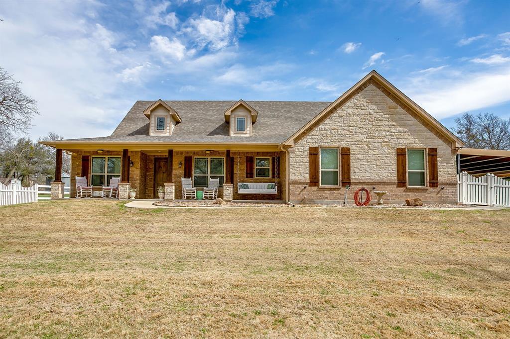 1615 Sanger Drive Springtown, TX 76082 - Photo 2 of 40 a front view of a house with a garden and patio