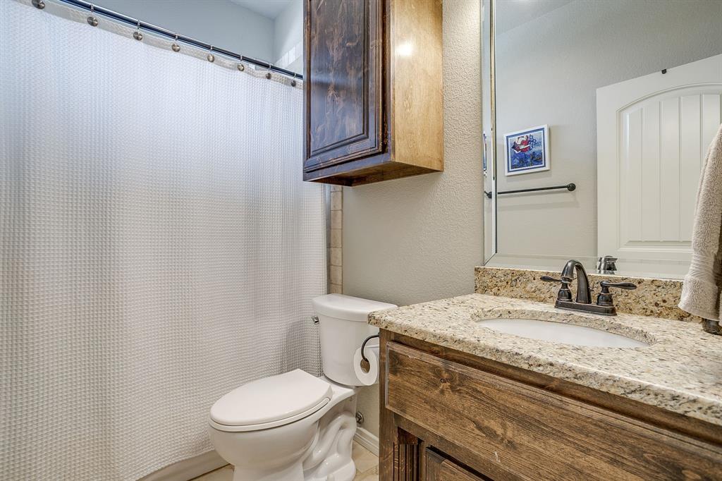 1615 Sanger Drive Springtown, TX 76082 - Photo 22 of 40 a bathroom with a granite countertop sink toilet and a mirror