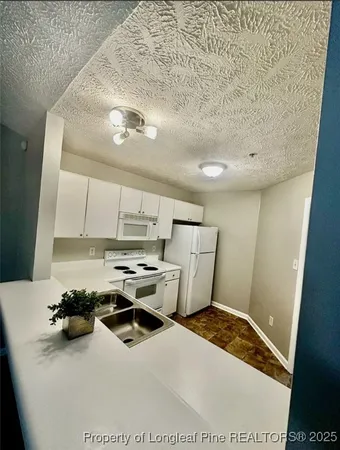 a kitchen with a sink appliances and cabinets