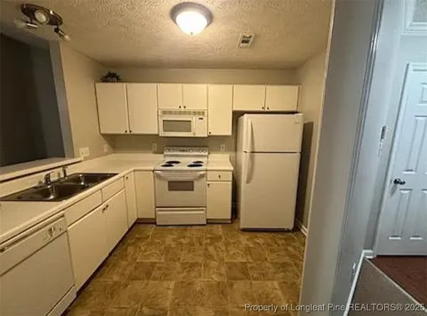 a kitchen with a sink a refrigerator and cabinets