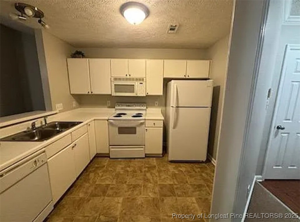 360 Bubble Creek Court, Unit 11 Fayetteville, NC 28311 - Photo 7 of 48 a kitchen with a sink a refrigerator and cabinets
