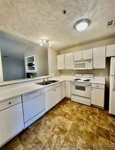 a kitchen with granite countertop a sink stainless steel appliances and cabinets