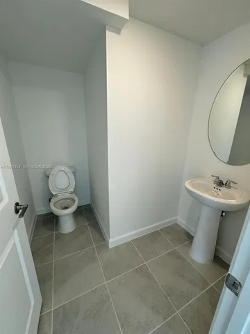 a bathroom with a toilet a sink and a mirror