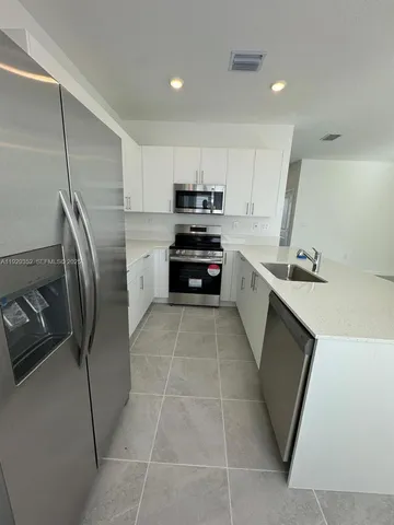 a kitchen with stainless steel appliances a refrigerator sink and stove
