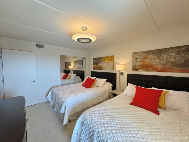 a bedroom with two beds and a large mirror