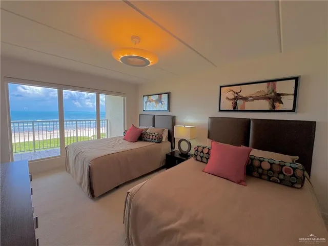 a bedroom with two beds and a large window