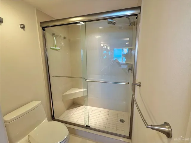 a bathroom with a glass shower door and a toilet