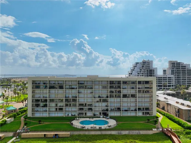 a front view of a building with windows and yard